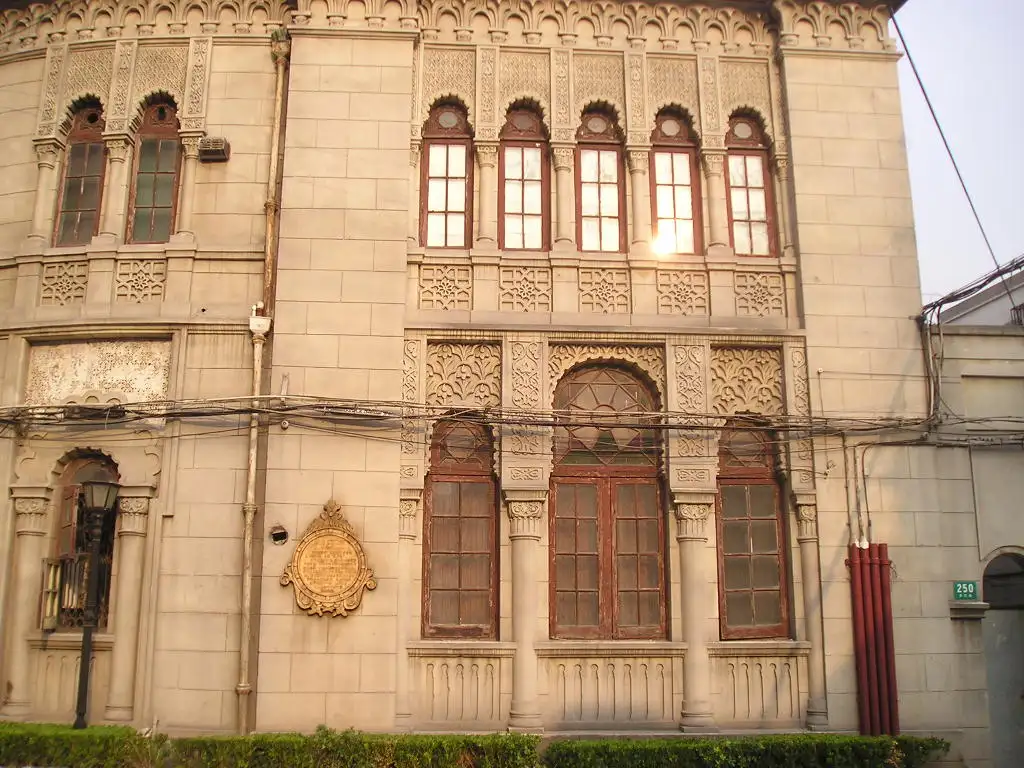 The ornate stone façade of 250 Duolun Road, with arched windows and carved details.