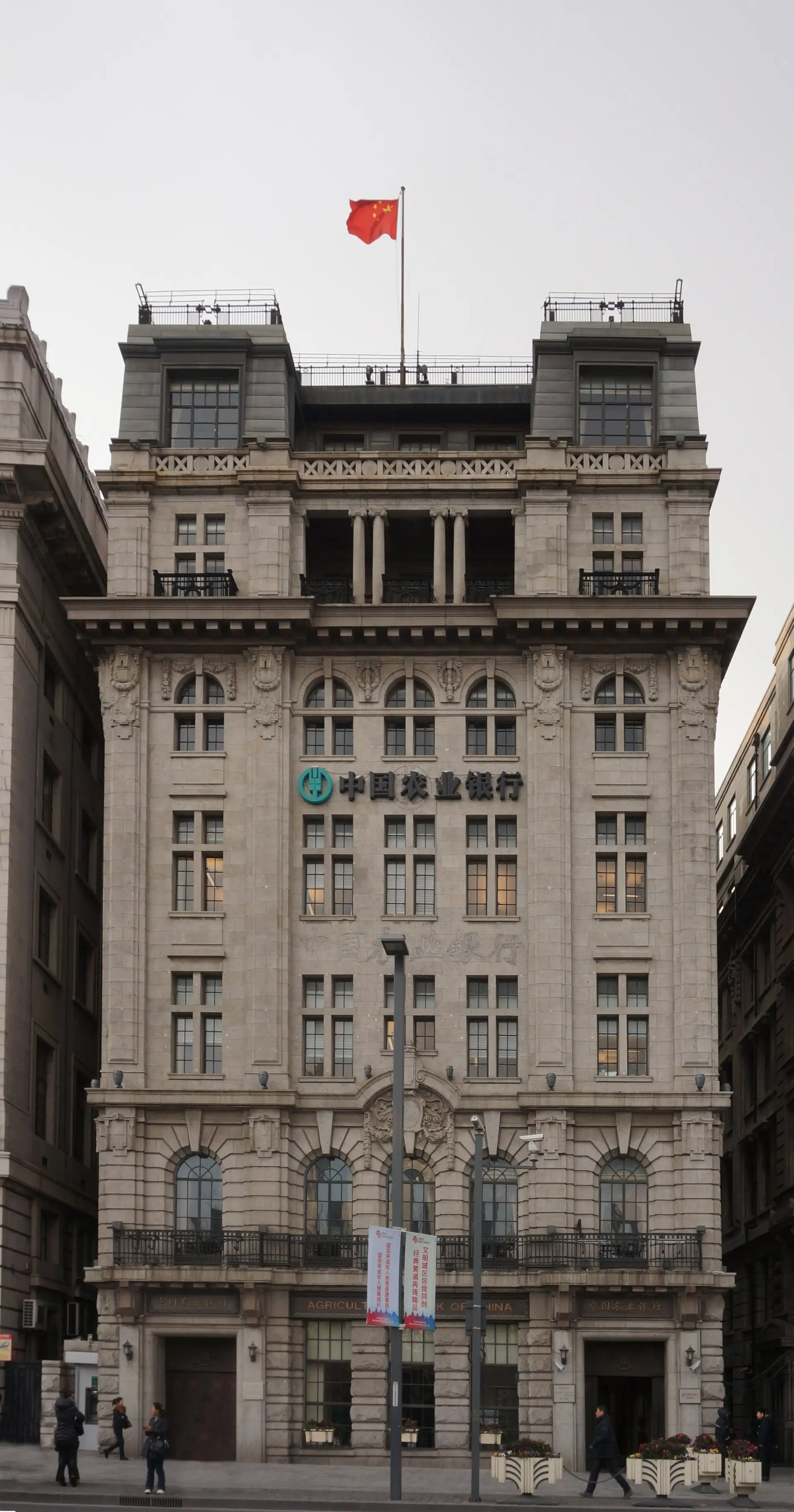 The Yangtze Insurance Building, a narrow seven-storey stone façade with a flag on top.