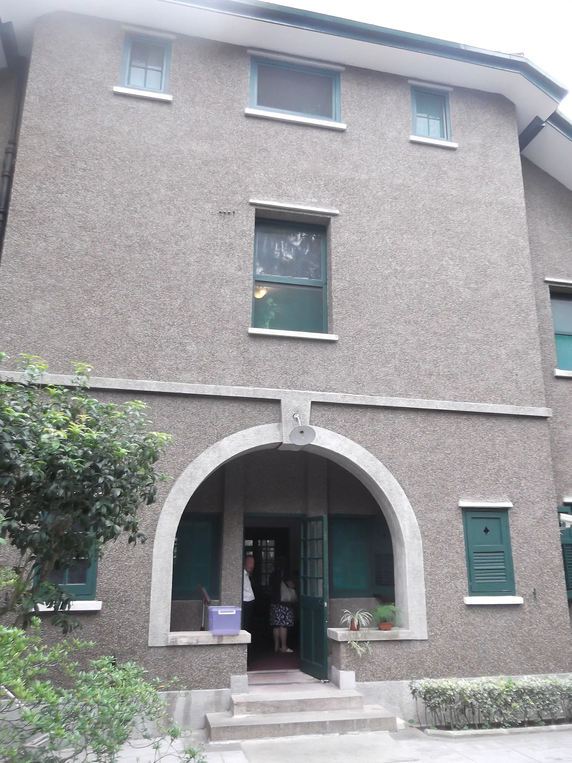 The front door of Ba Jin's former residence, an arched entrance in a grey rendered wall.