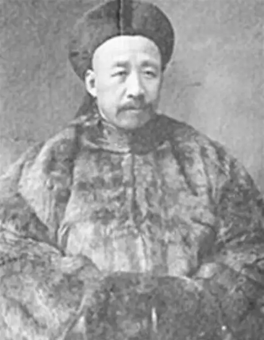 Black-and-white portrait of a man with a moustache wearing a Qing hat and a heavy fur coat.