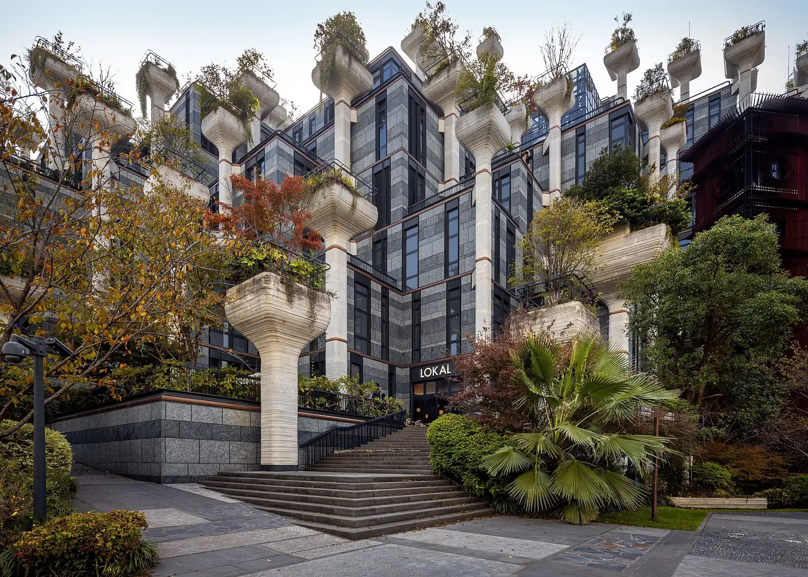 Stepped terraces at 1000 Trees, with planted concrete columns, glass fronts and broad outdoor stairs.