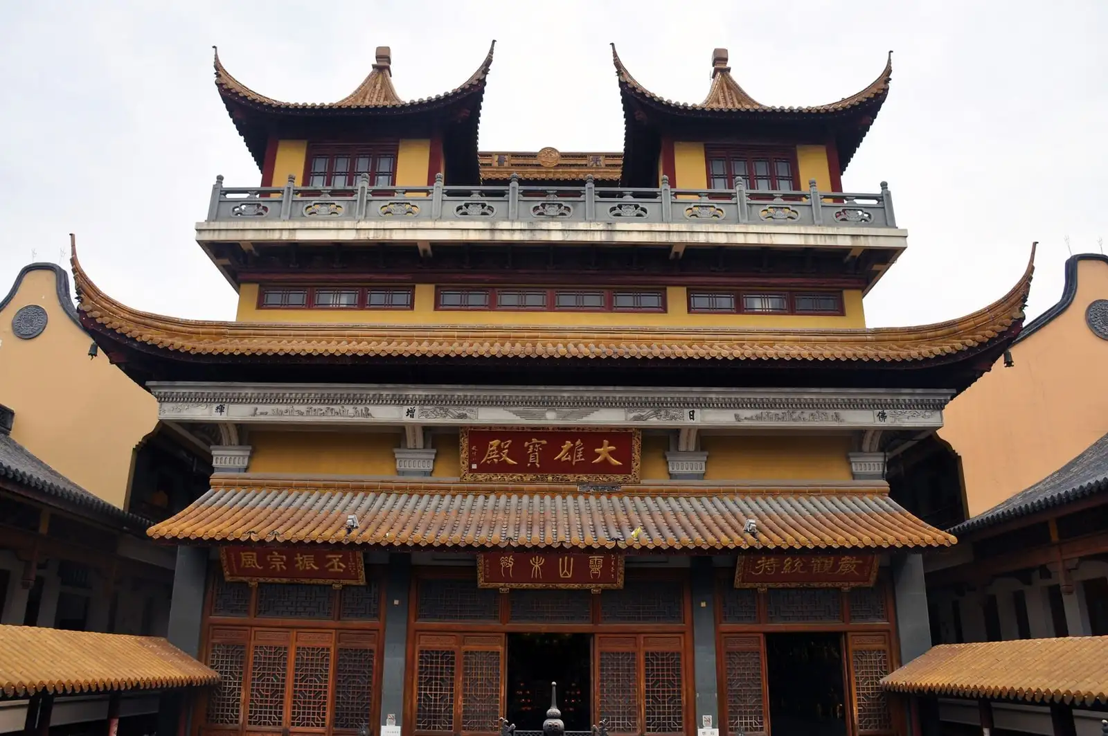 The multi-storey yellow facade of Fazang Temple, with dark tiled roofs and a red entrance.