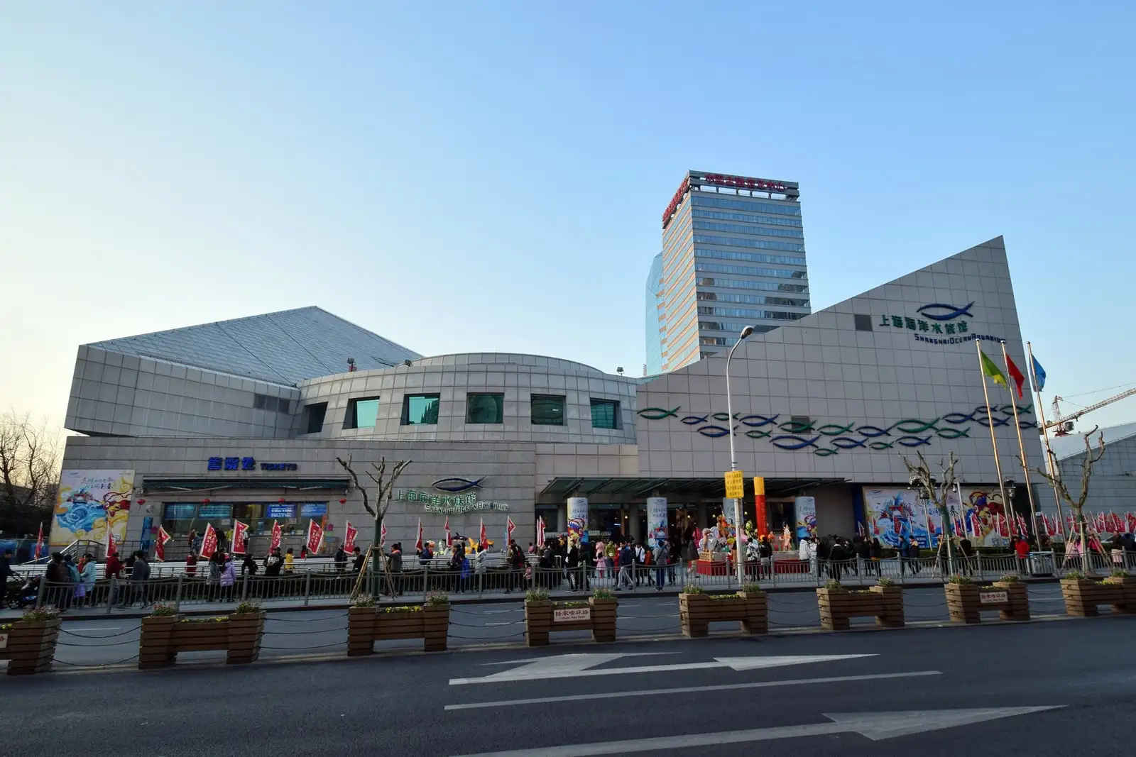 The street entrance of Shanghai Ocean Aquarium, with angular rooflines and fish outlines on the facade.