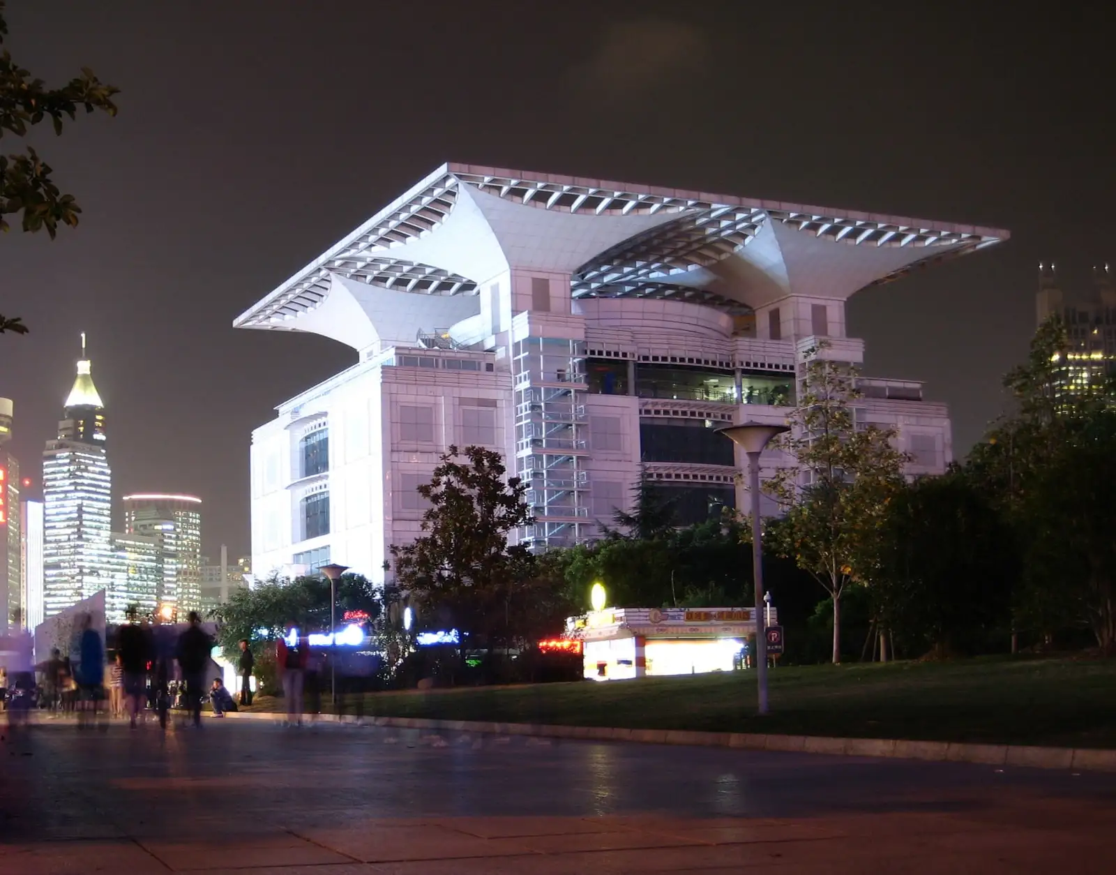 Shanghai Urban Planning Exhibition Center lit at night, with its distinctive open roof structure.