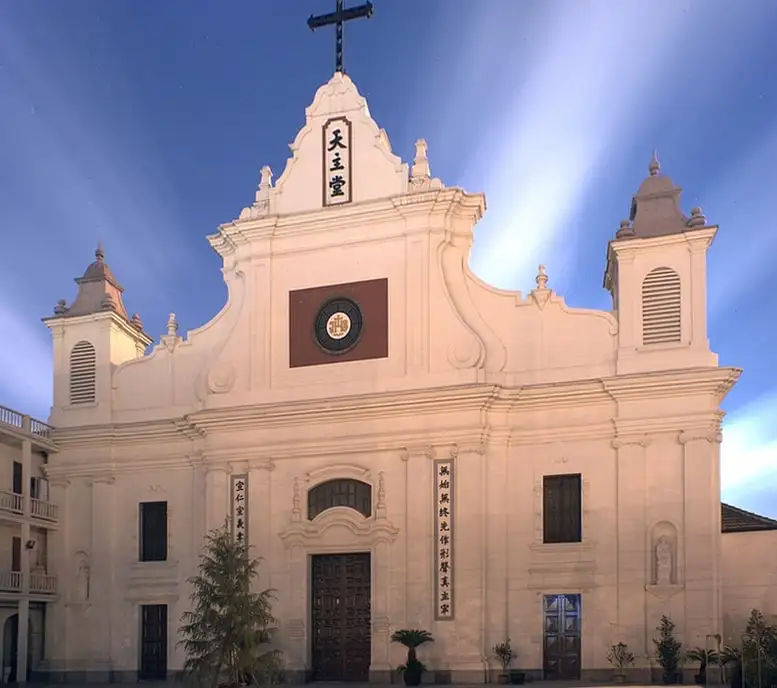 The pale facade of Dongjiadu's St. Francis Xavier Church illuminated after dark.