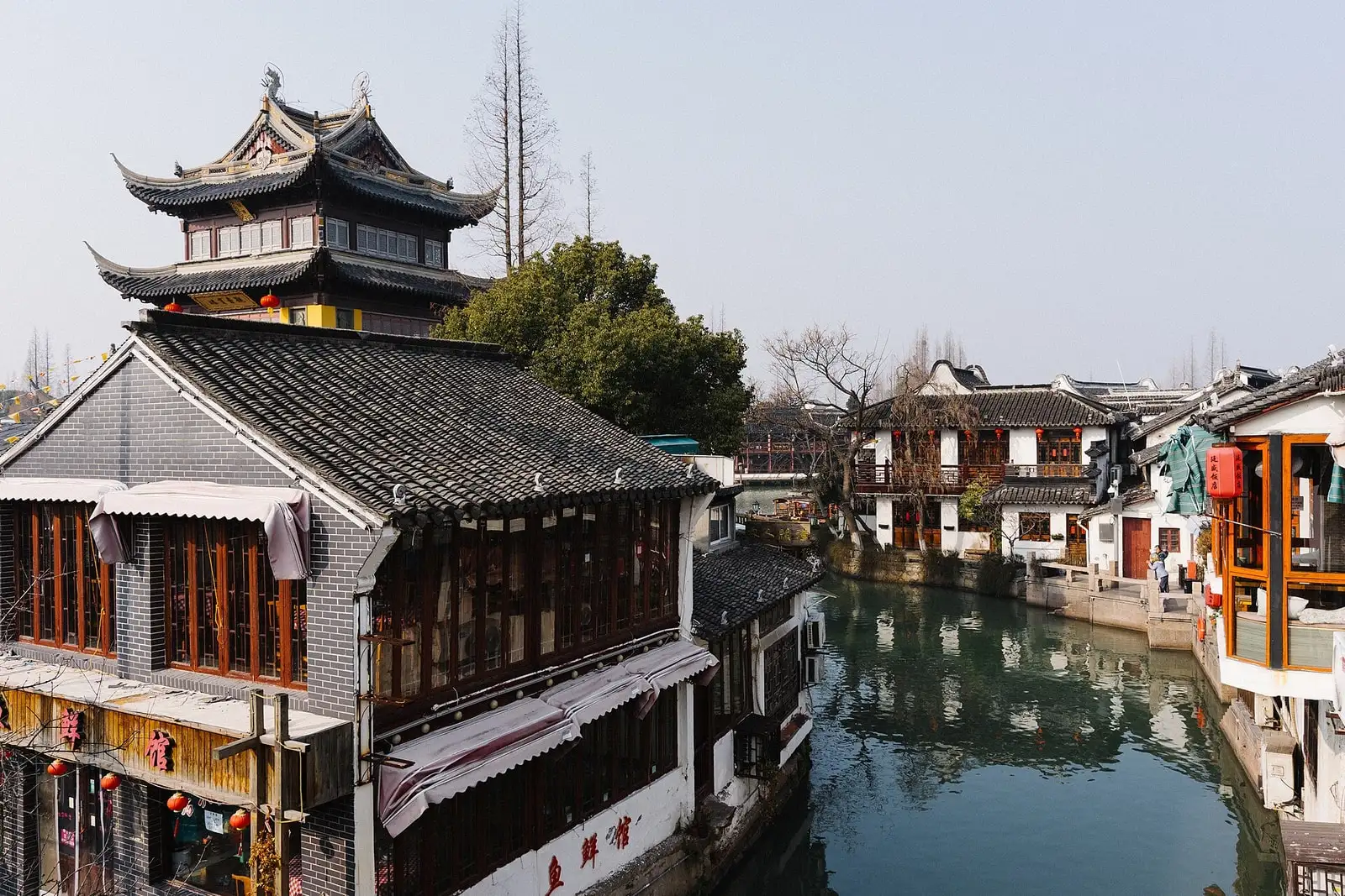 A narrow canal at Zhujiajiao, lined with white walls, timber balconies and tiled roofs.
